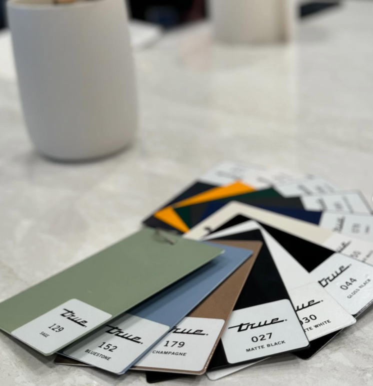 Color swatches fan out on a white table next to two white mugs.