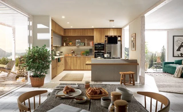 Open-concept kitchen and dining area with a breakfast table, kitchen island, wooden cabinets, and large windows showing outdoor seating.