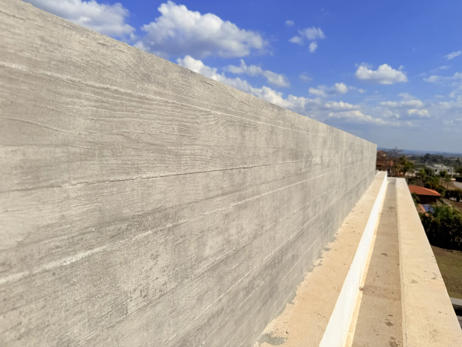 Casa Acolher: long wall clad in board-formed concrete sheets