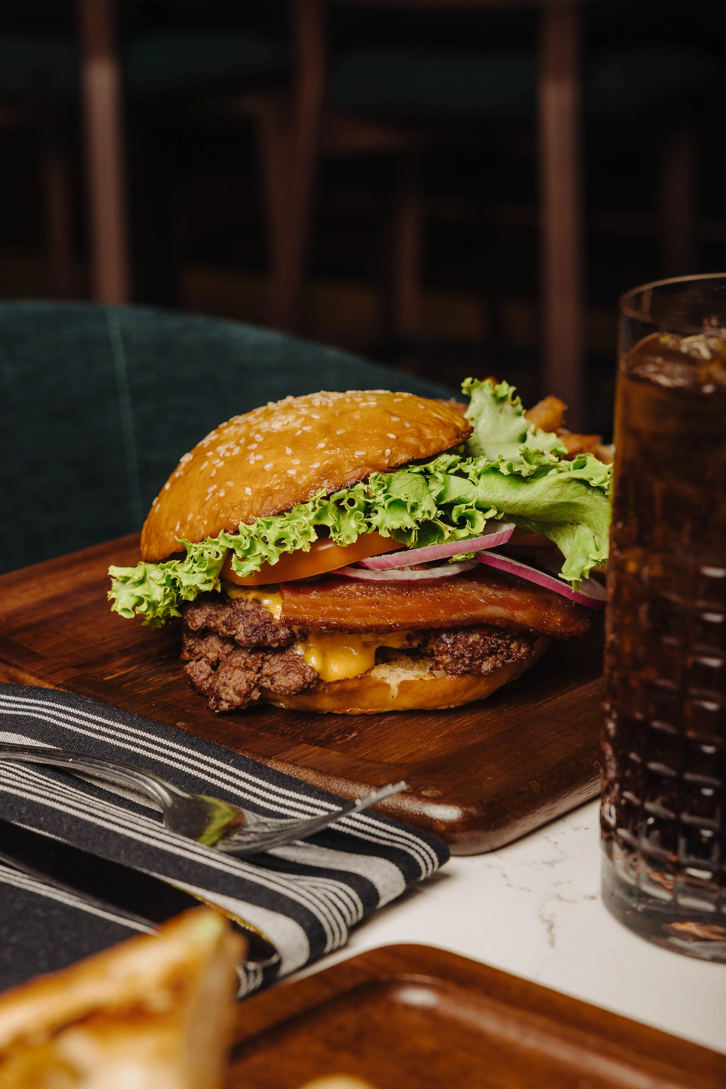 Kindred Table's cheeseburger featuring 2 smash wagyu patties, American cheese, Nueske’s bacon, lettuce, tomato, onion, pickle, milk bun