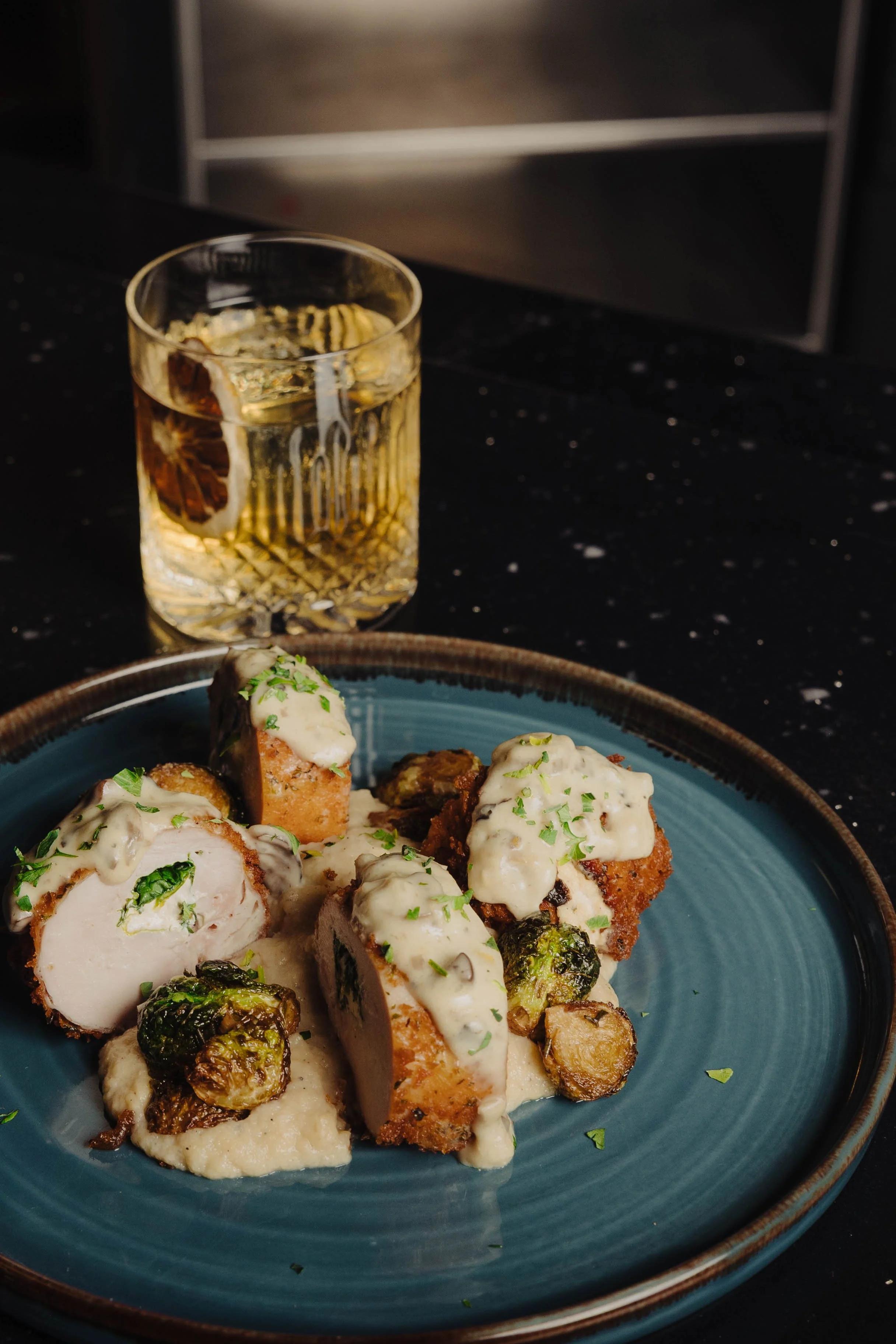 Stuffed Chicken Breast featuring panko crusted chicken, spinach, boursin cheese, mushroom cream sauce, cauliflower smash, roasted root vegetable sauté 