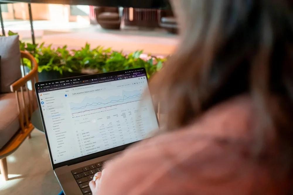 Laptop with analytics: A person reviewing website traffic and performance data in Google Search Console on a laptop in a café setting.
