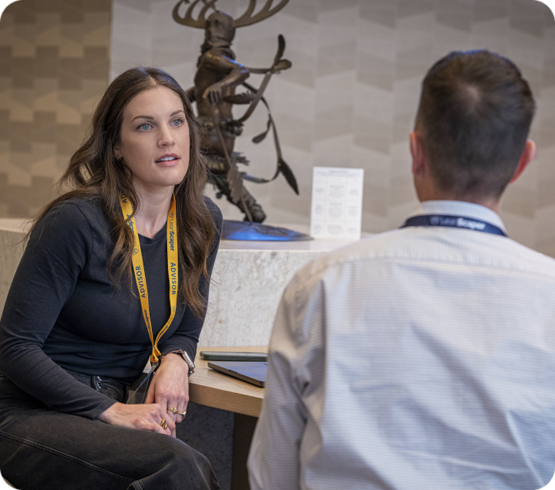 Advisory conversation at LeanScaper event: Jaden Miller, wearing a LeanScaper Advisor lanyard, in a one-on-one conversation with a landscape business owner at a LeanScaper event.