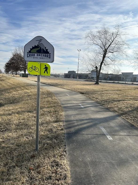A paved path with a sign marking the path