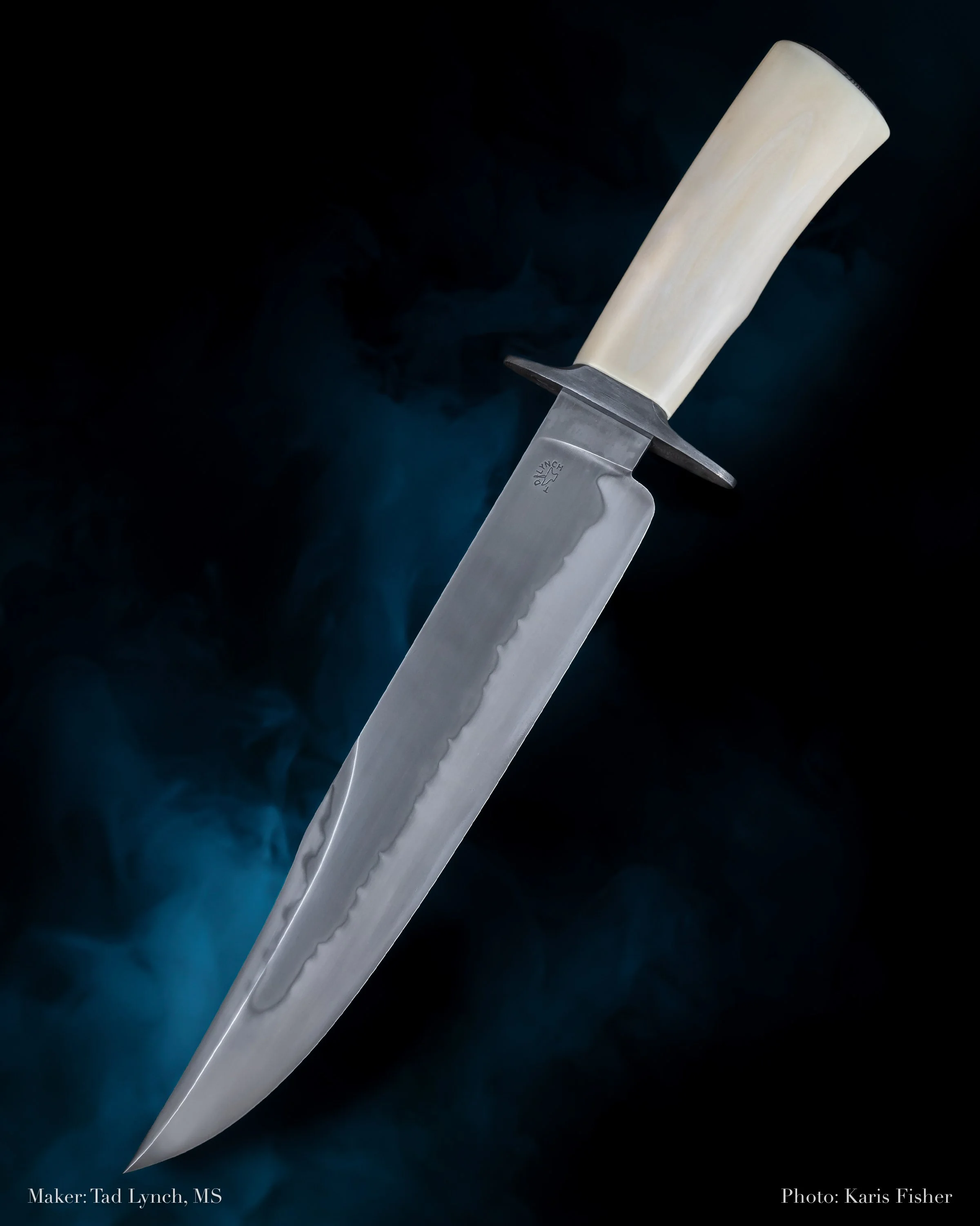 A large hunting knife with a light-colored handle and a wide, sharp blade against a dark, smoky background.