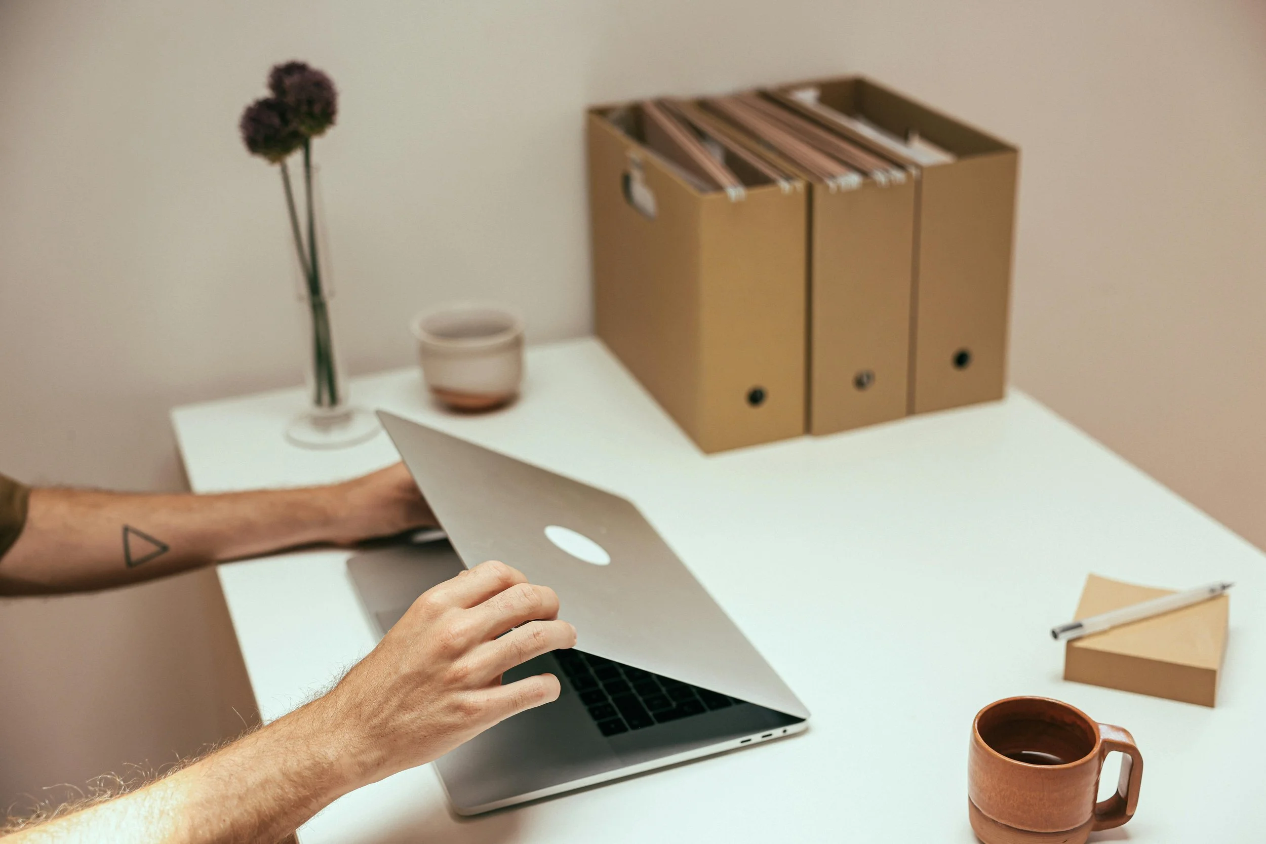 A professional closing their laptop and taking a deep breath, illustrating the relief and nervous system regulation achieved through a therapy intensive.