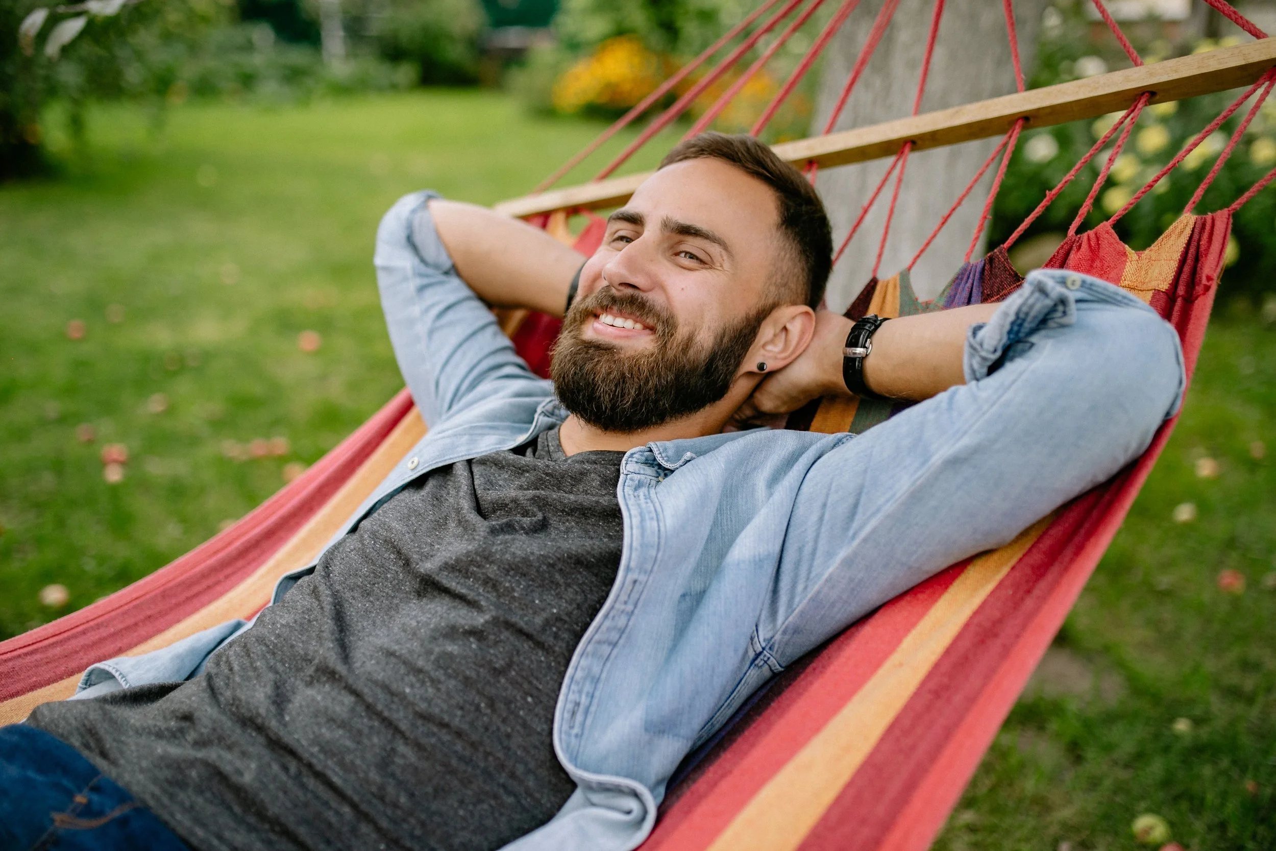 An adult relaxing comfortably and unplugging from work, demonstrating the nervous system regulation and reduced chronic stress achieved through therapy