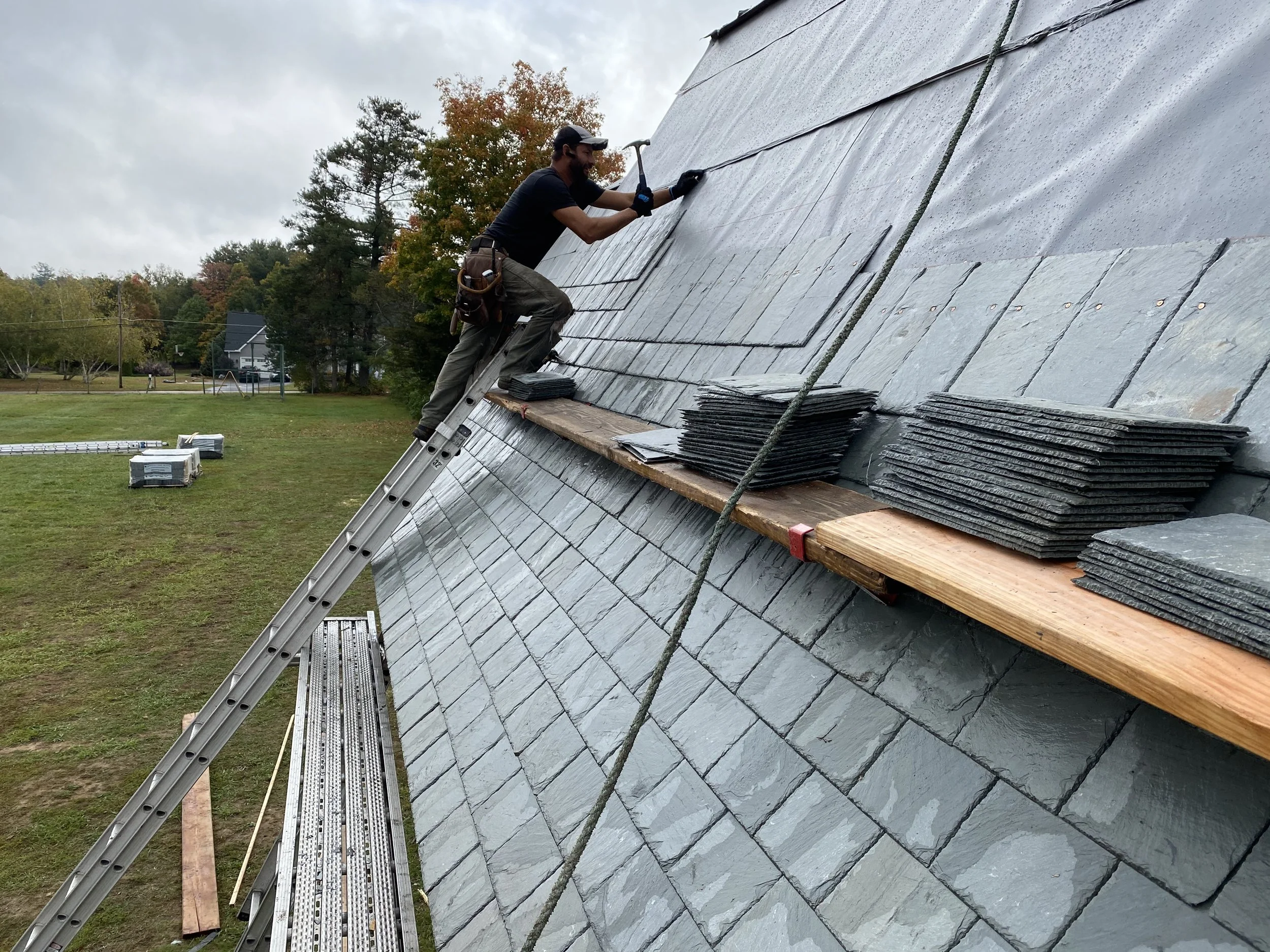 Man working on a slate roof