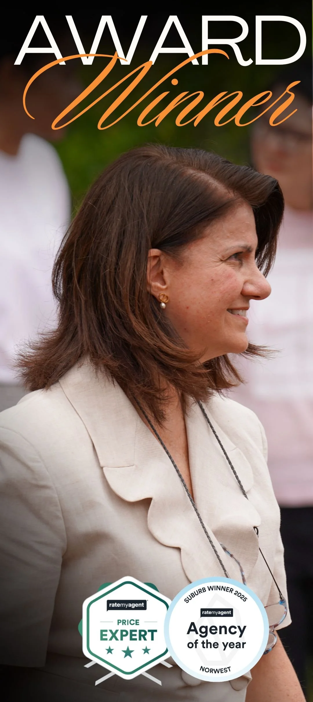 Side profile of a woman with brown hair wearing earrings and a light-colored blazer, smiling, with awards and badges in the foreground.