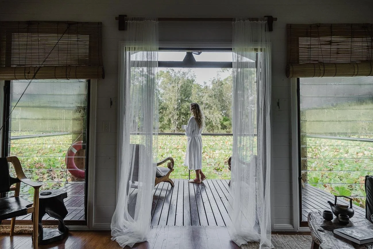 A Woman Facing the Lotus Pond While In The Boathouse at Leaves And Fishes