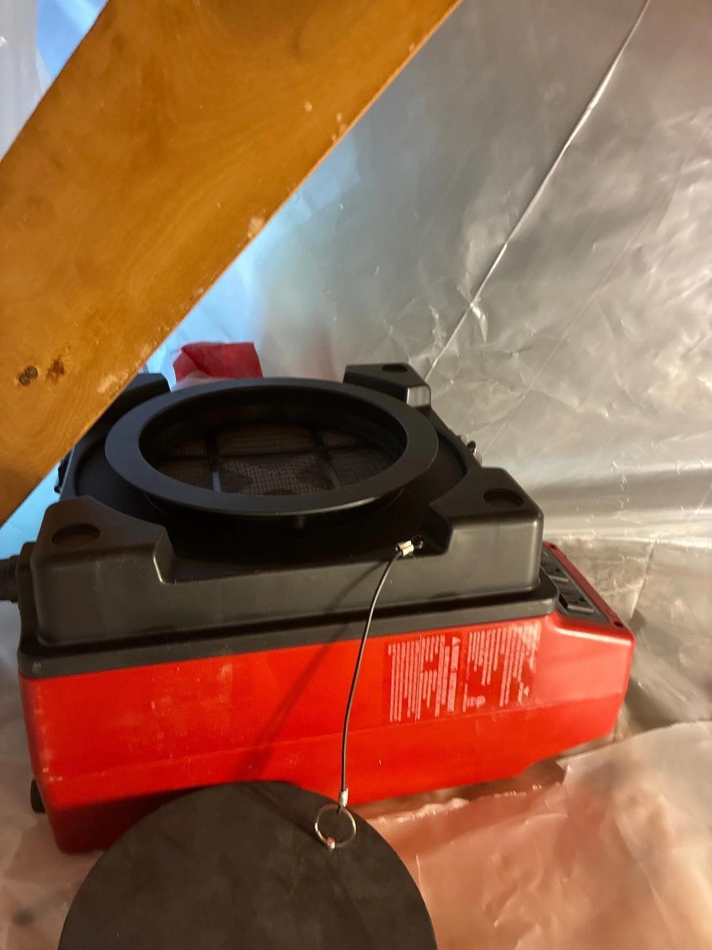 HEPA-filtered negative air machine operating inside containment during mold remediation.