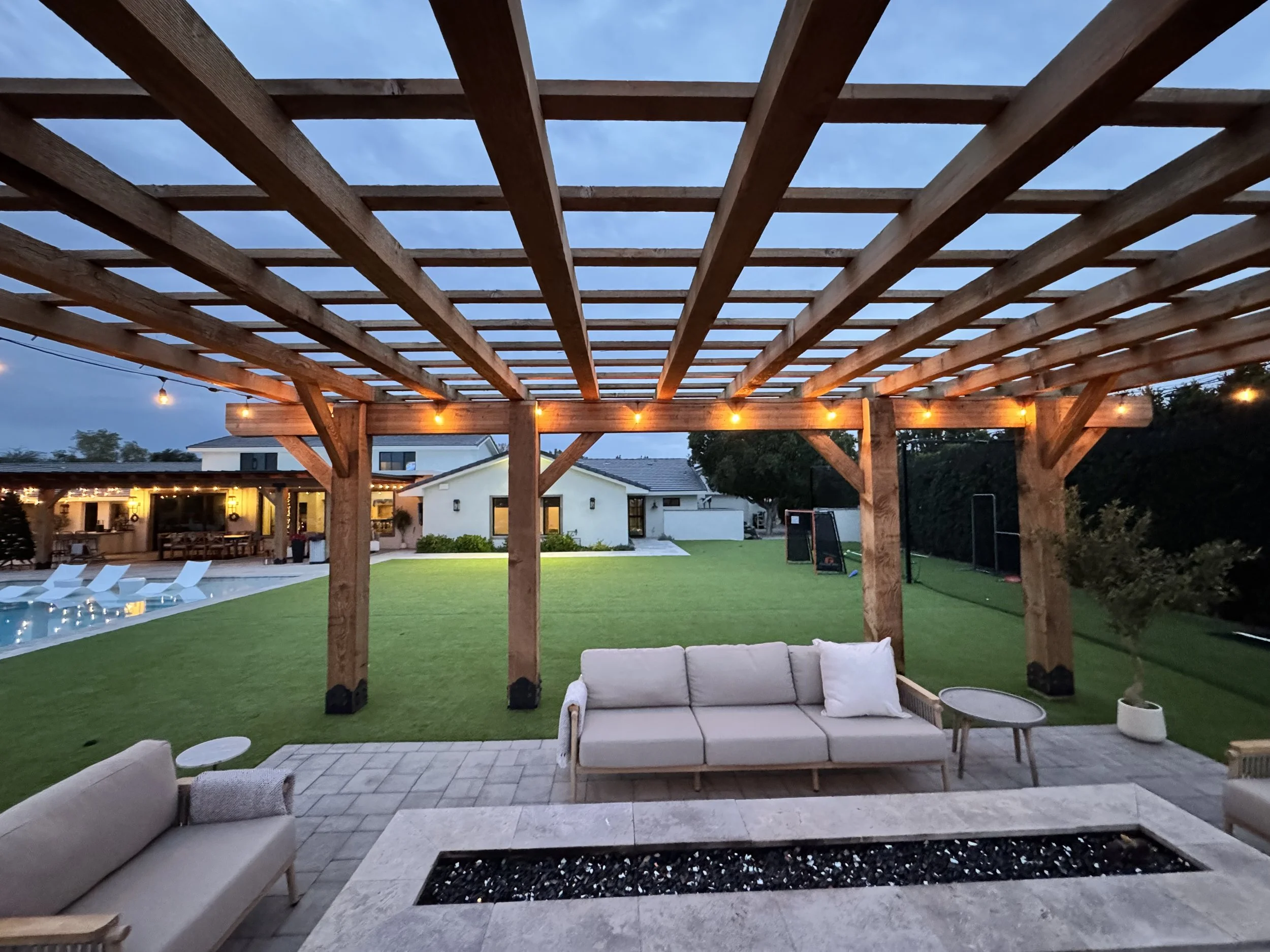 Big back yard with a pergola and bistro lights