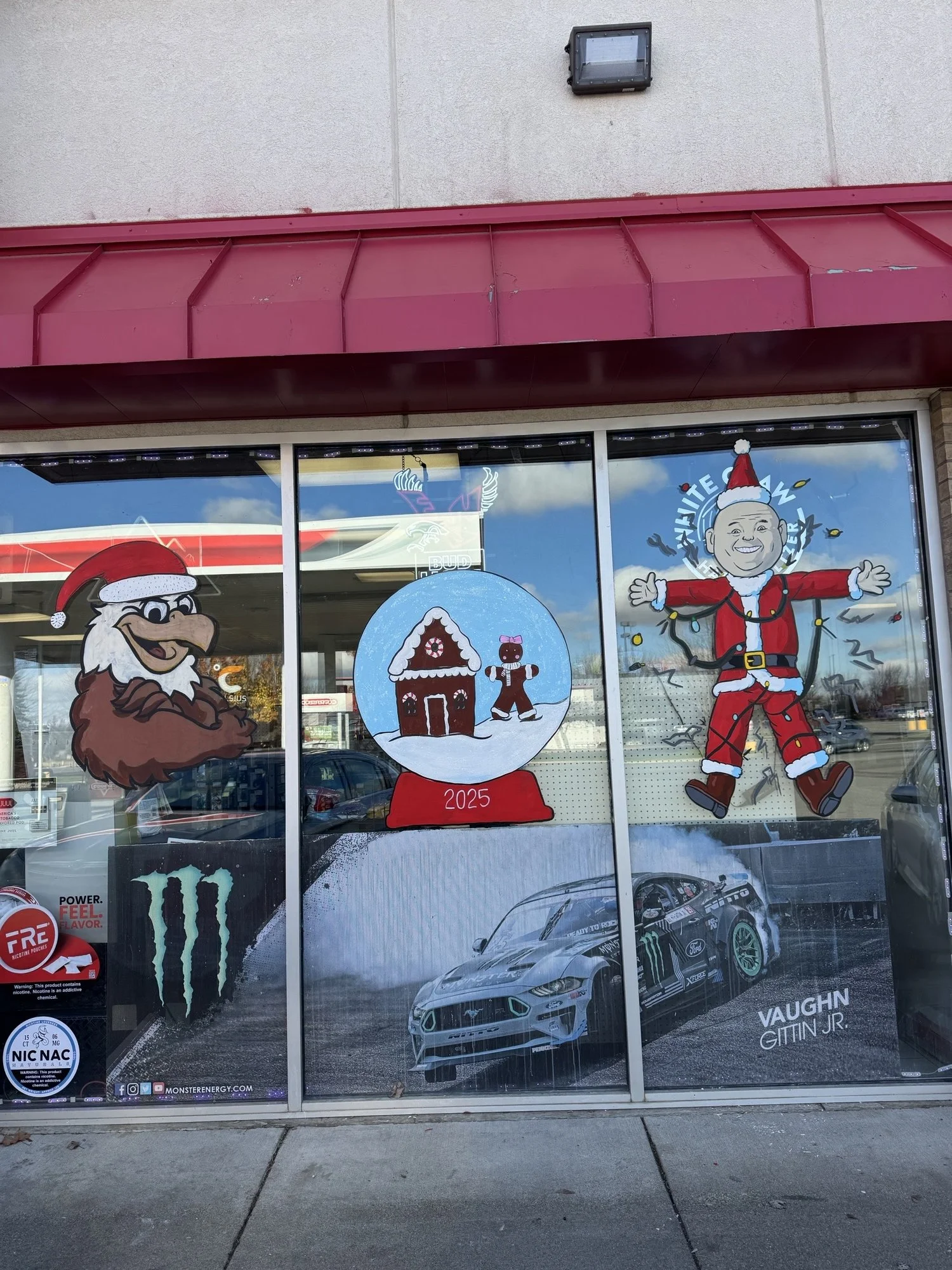 Christmas windows at Cheney Conoco featuring a custom request of the owner as Santa.