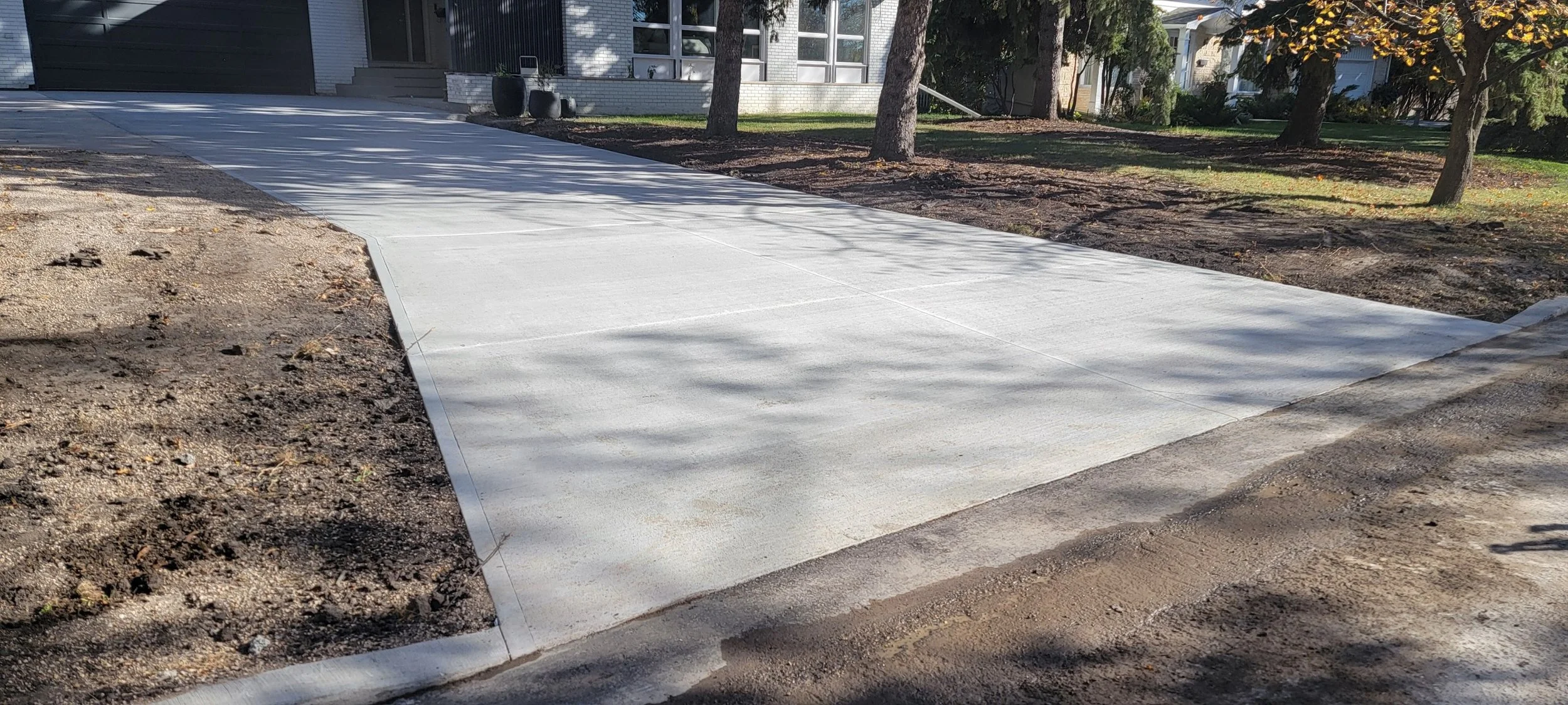 Newly poured concrete sidewalk in front of a house.