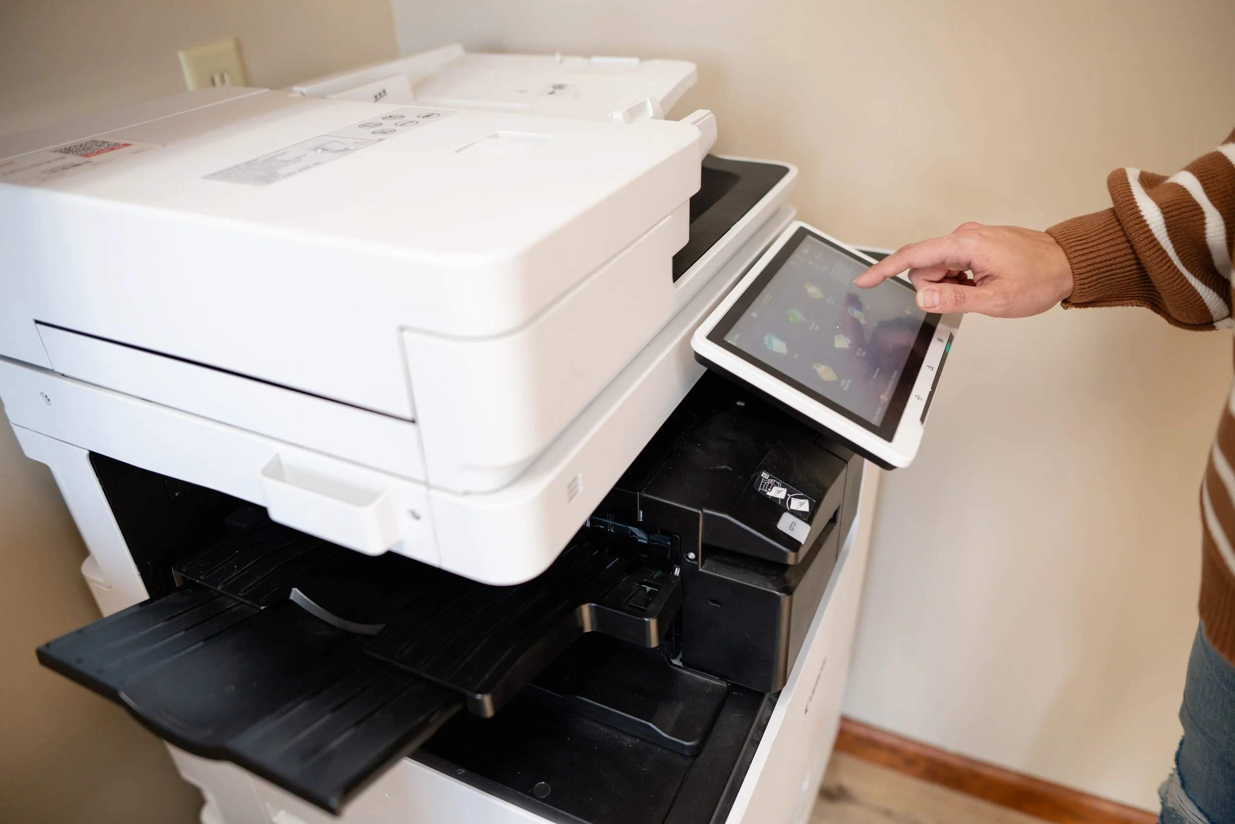 Member using the free color printing and scanning station at MindSpace Collective coworking and private office space in Bloomington.
