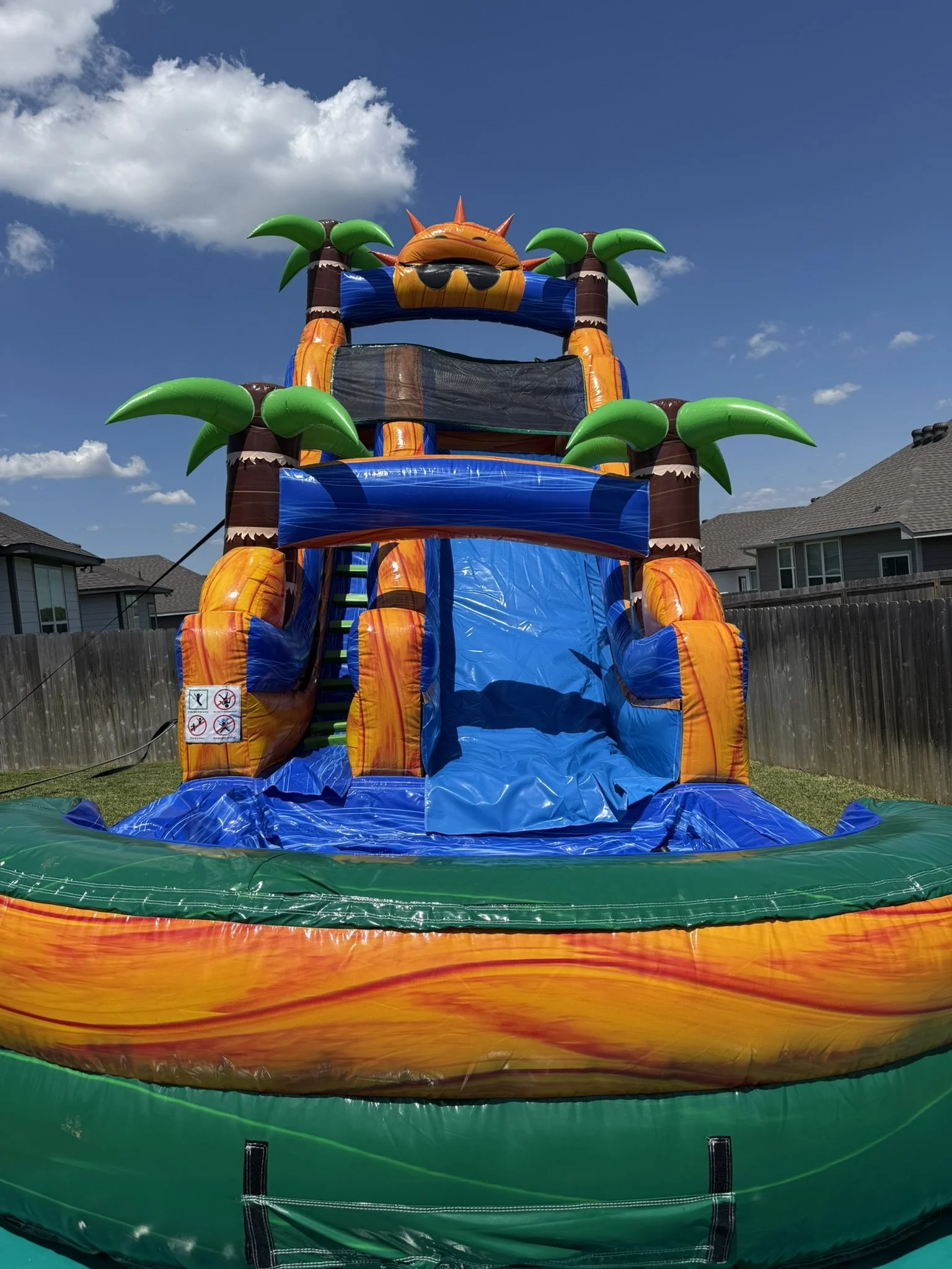 Front view of a 20ft Tropical Water Slide rental in a College Station backyard.