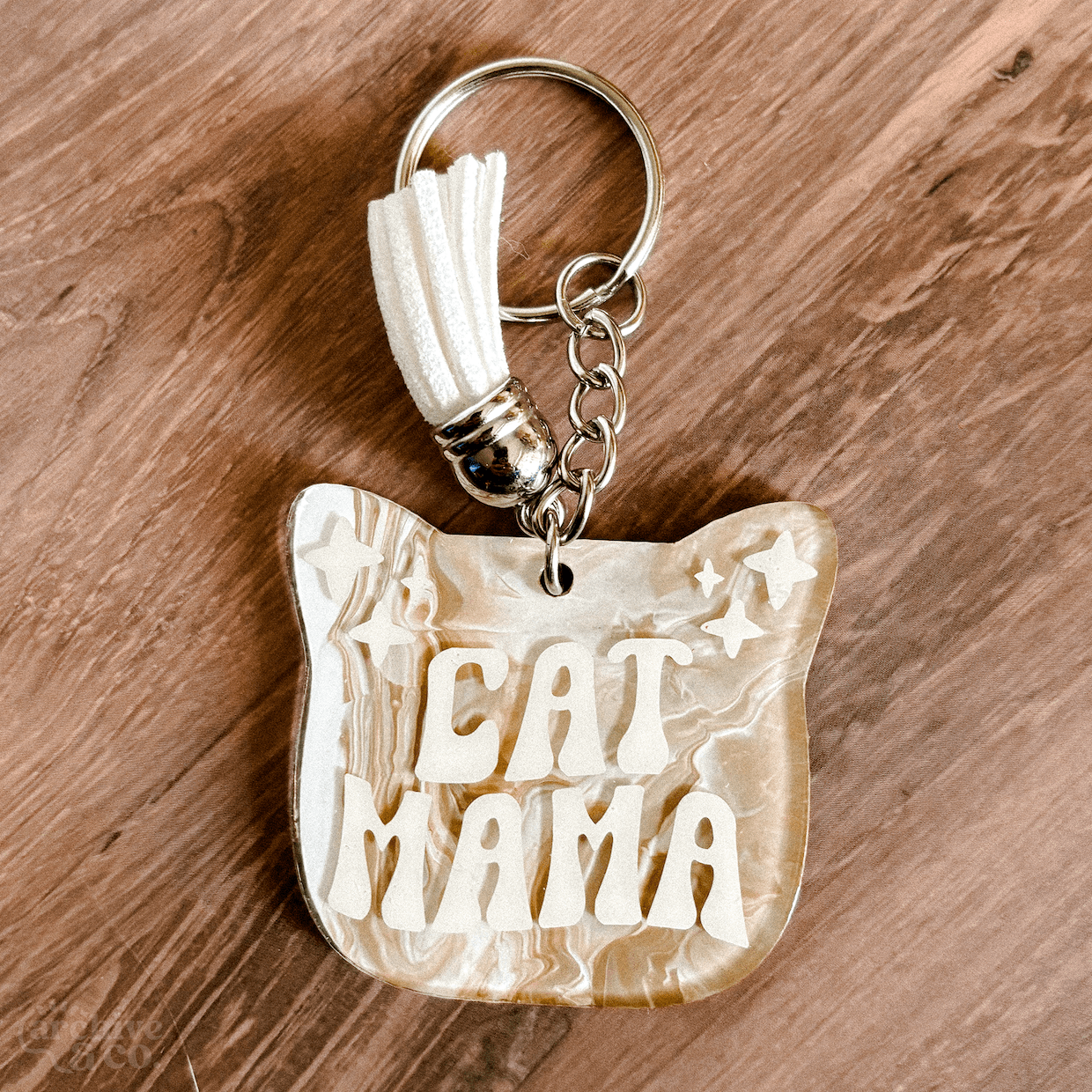 handmade cat mama keychain with light neutral marbled pattern, white cat mama lettering, coordinating tassel, and silver keyring