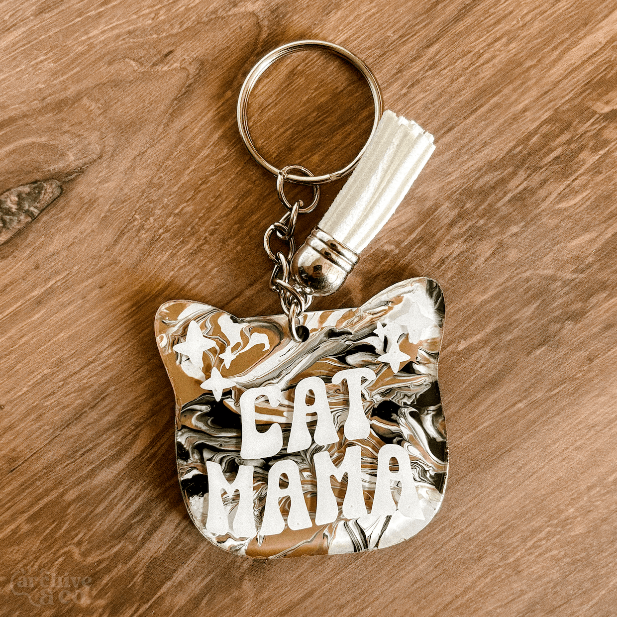 handmade cat mama keychain with light cream and white marbled fur-inspired pattern, retro cat mama lettering, tassel, and silver keyring