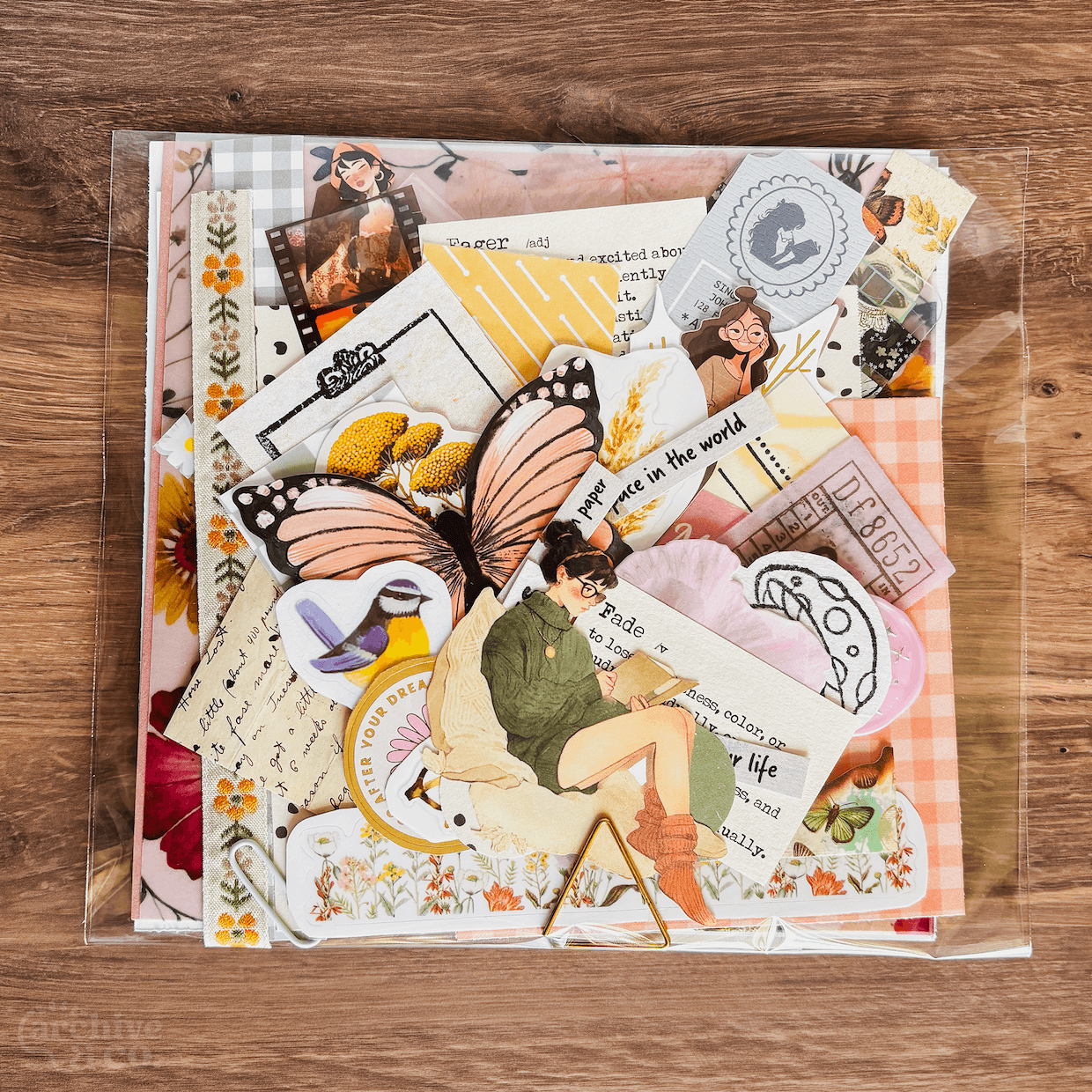 50-piece junk journal ephemera kit with colorful decorative papers, illustrations, stickers, photographs, and handmade paper details