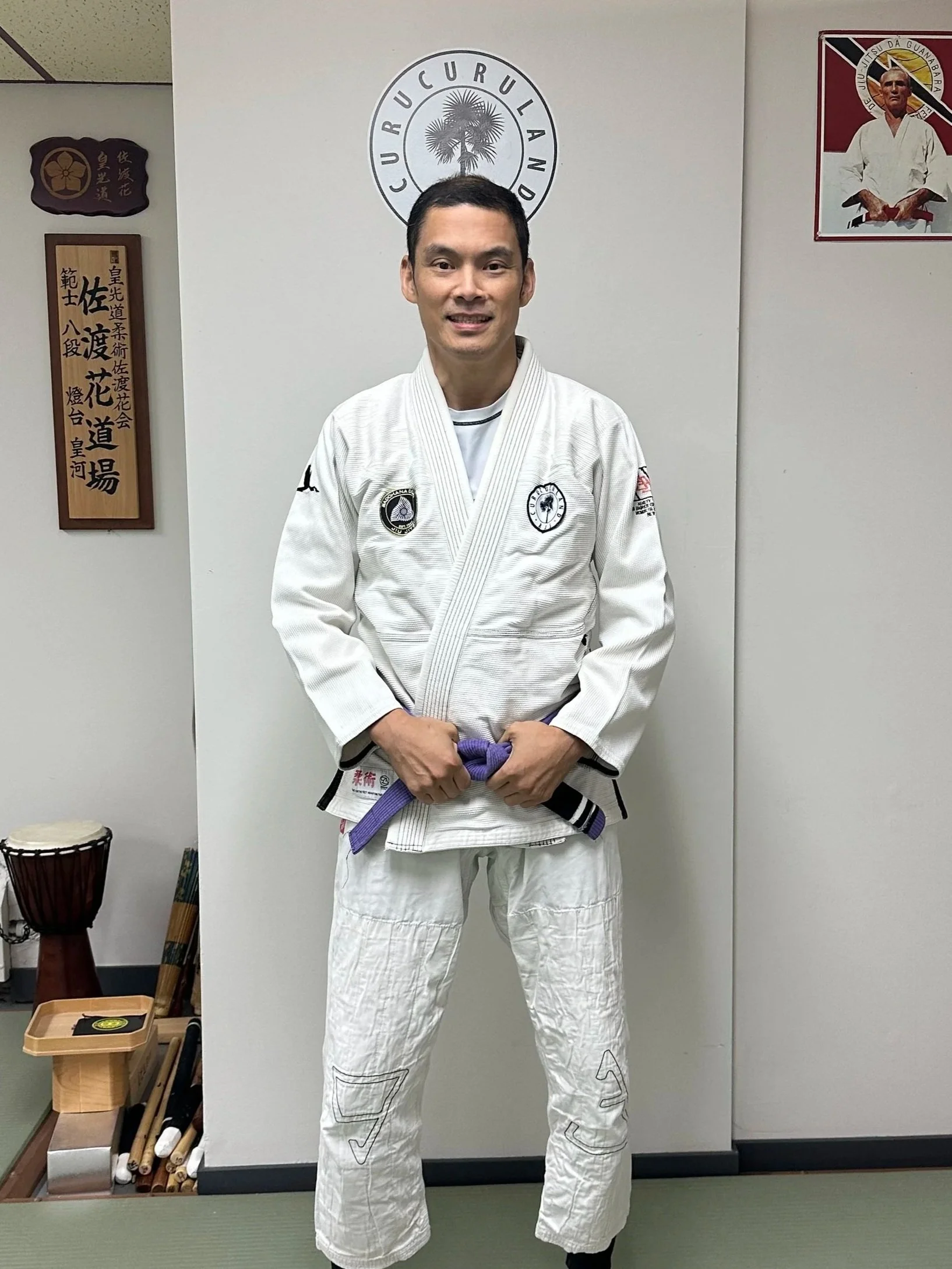 Jonathan Yim wearing a white Brazilian Jiu-Jitsu gi with patches and a purple belt standing at Sadohana Dojo in Vancouver BC Canada