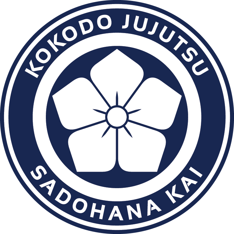 Logo of Kokodo Jujutsu Sadohana Kai featuring a stylized flower in the center with five petals and the organization's name encircling it.