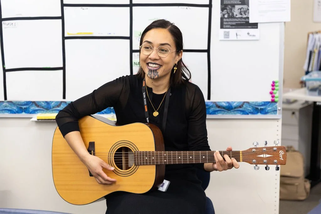 Dr Mania Campbell-Seymour, one of the founders of Te Wairoa Medical Centre, playing guitar for waiata session after karakia.