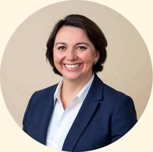 Professional woman with shoulder-length dark hair, wearing a navy blazer and white shirt, smiling against a neutral background.