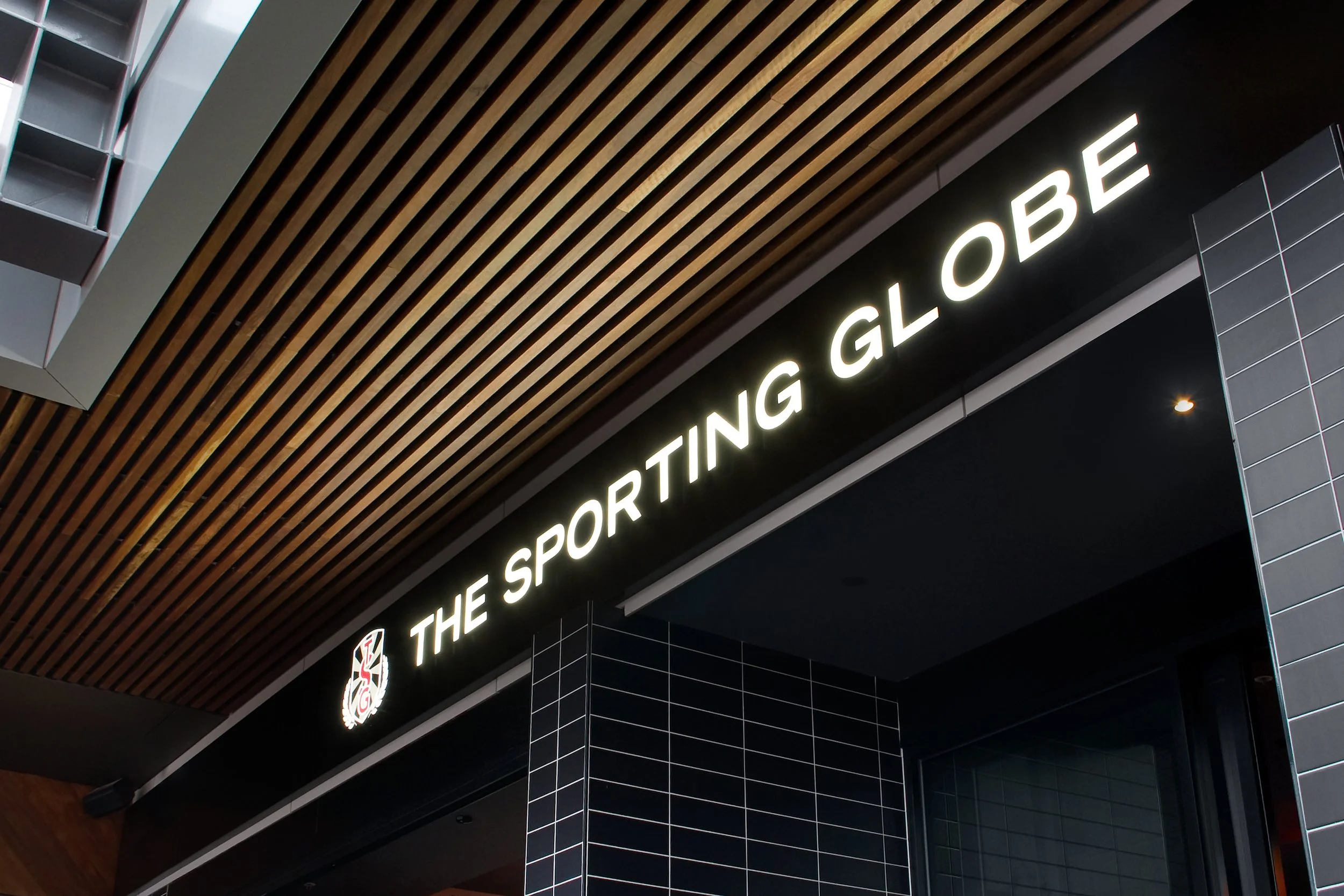 Sign for The Sporting Globe restaurant in a modern interior