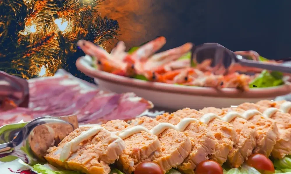 Christmas dinner buffet with salmon, prawns and various dishes on a table near a decorated Christmas tree