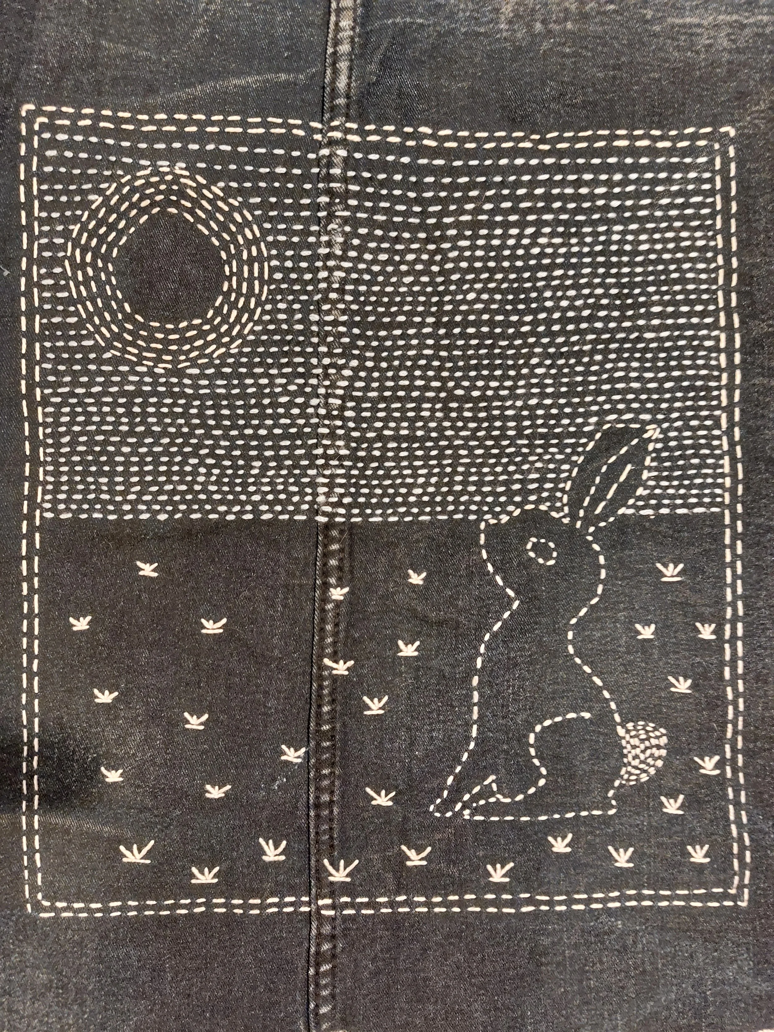 Dark denim looking cloth which has been embroidered using simple white running stitches depicting a hare gazing at the moon.  This is one of the available Boro Kits