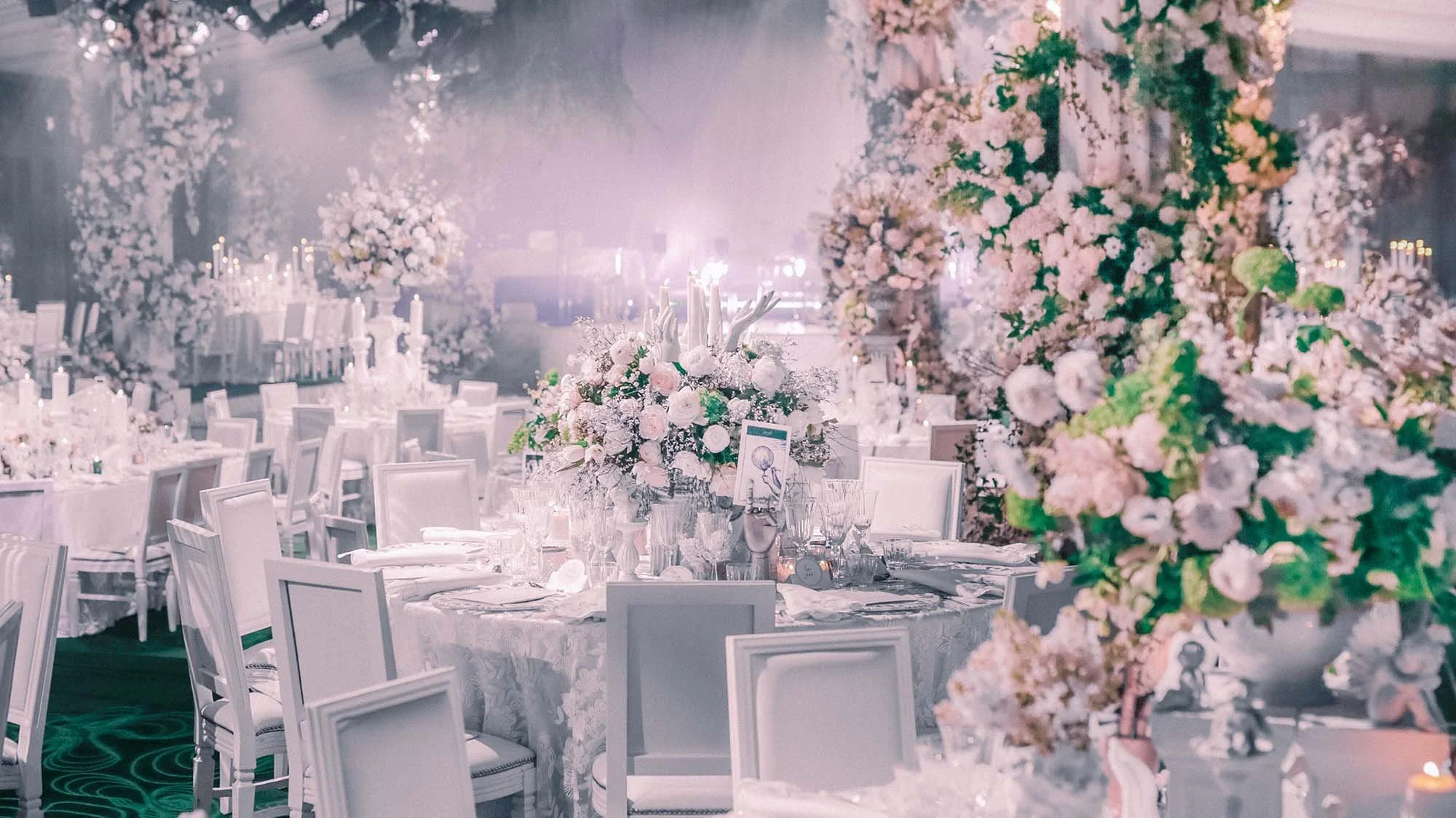 Wedding reception design using a white colour palette fro elegant floral displays and place settings.