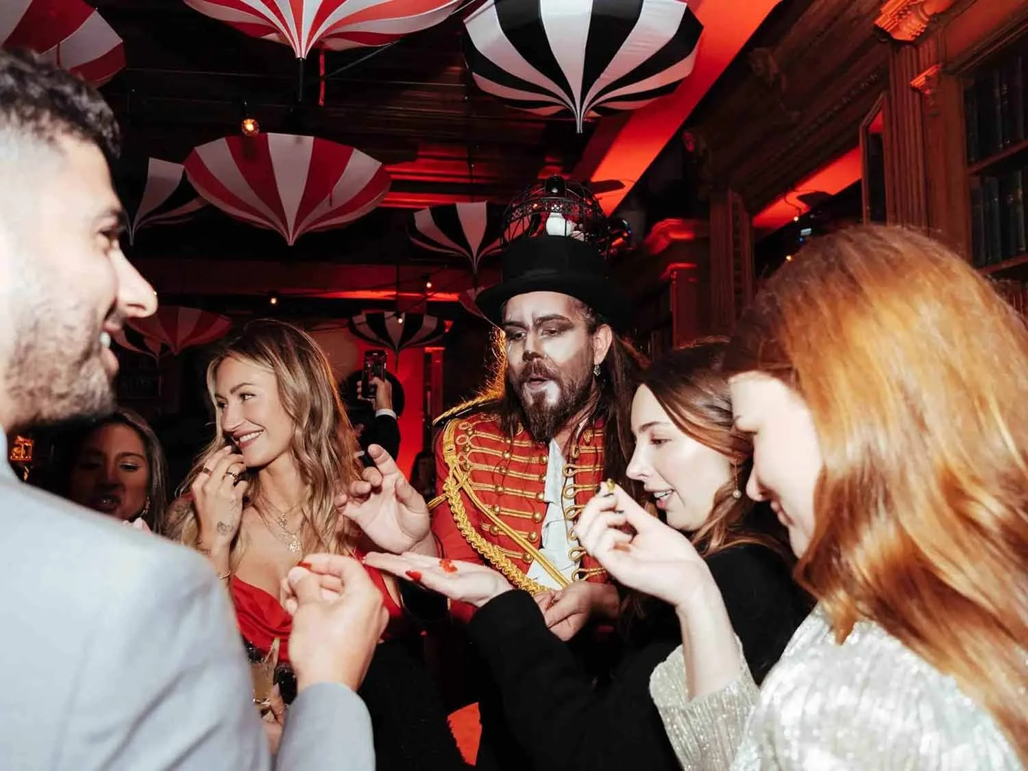 Man dressed as a vintage circus ringmaster entertains guests at a private event