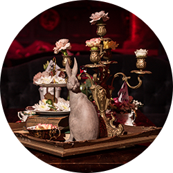 Decorative display with a tea set, flowers, and a rabbit figurine on a tray