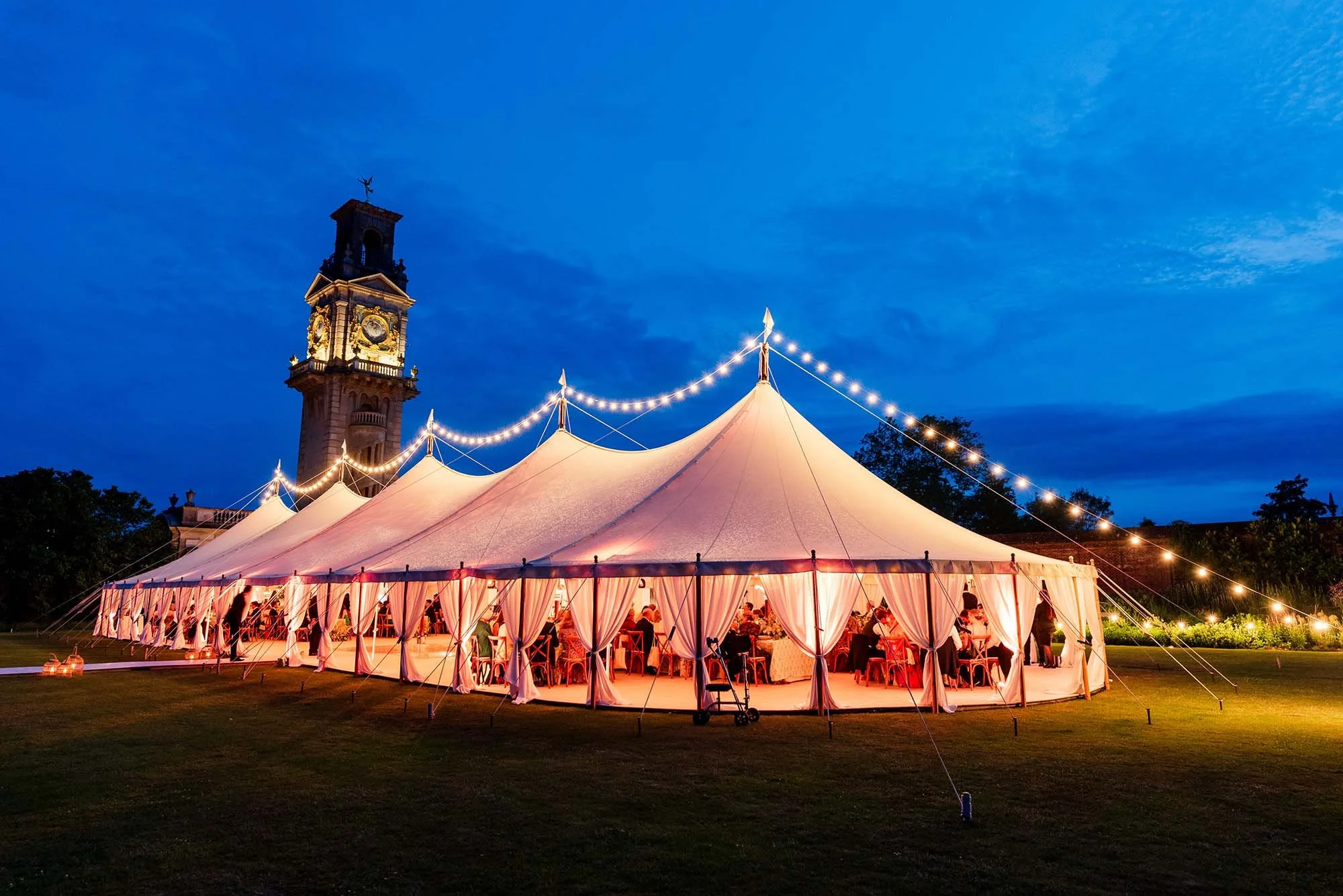 Beautifully lit marquee for wedding reception in the grounds of Cliveden House.