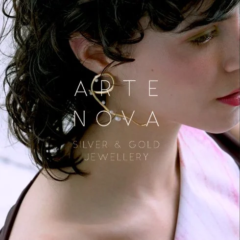 Imagem de um close no pescoço de uma mulher com brincos de argola e cabelo cacheado, com texto sobreposto.