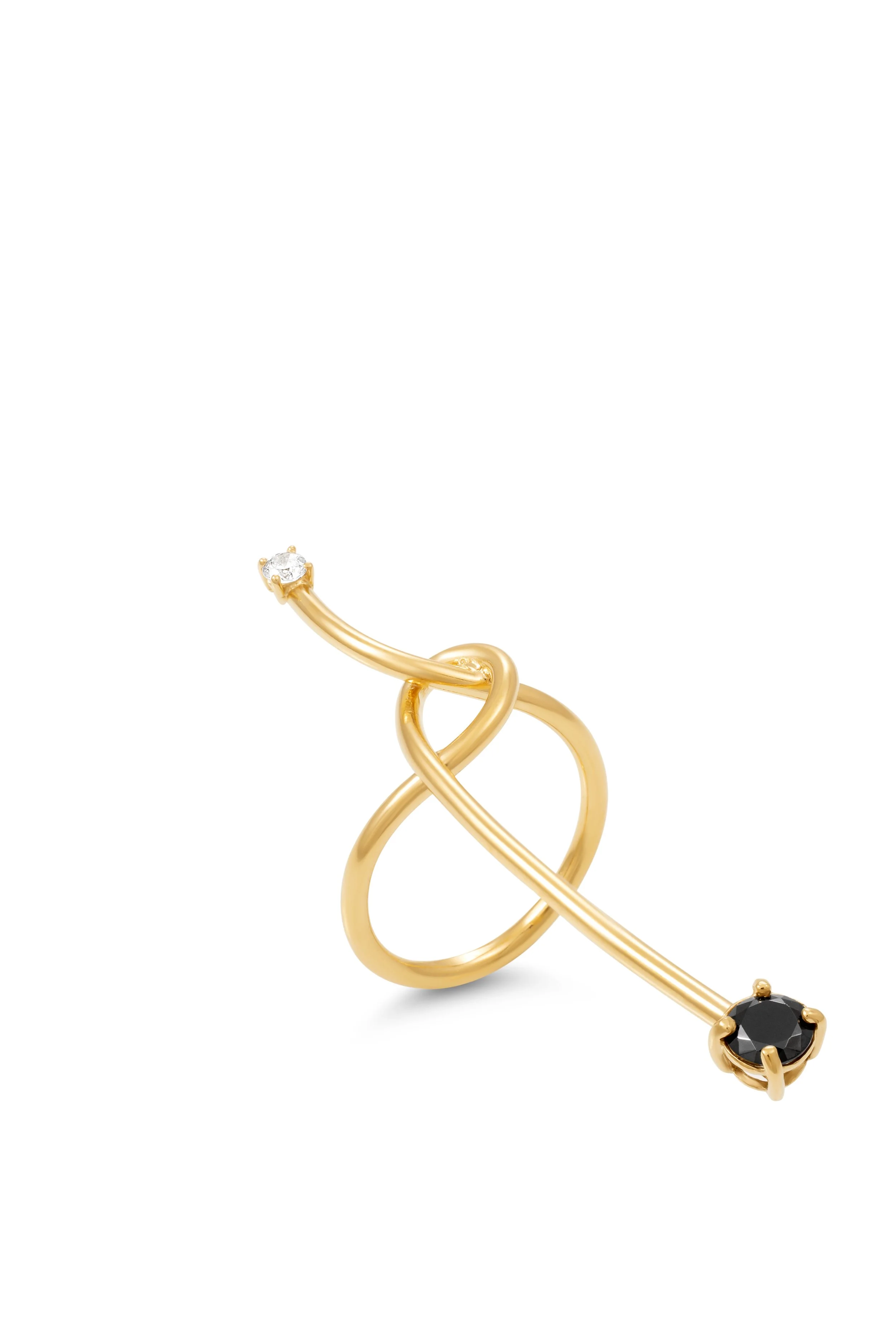 Anel dourado com design abstrato, contendo uma pedra branca e uma pedra preta.