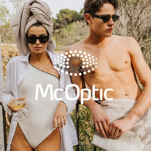 Homem e mulher usando óculos escuros ao ar livre, com a mulher vestida com maiô e toalha na cabeça, segurando uma taça, enquanto o homem está sem camisa segurando um jornal. Logo da McOptic na imagem.