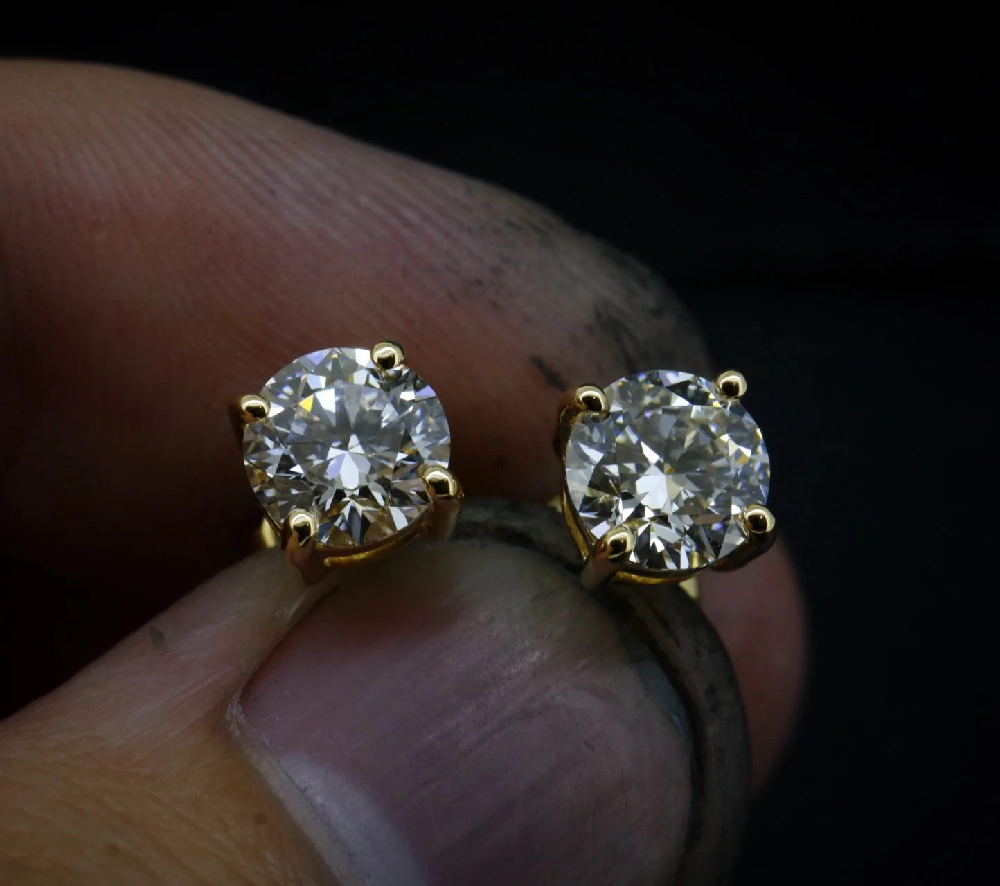 Pair of diamond earrings with round cut stones set in yellow gold prongs.
