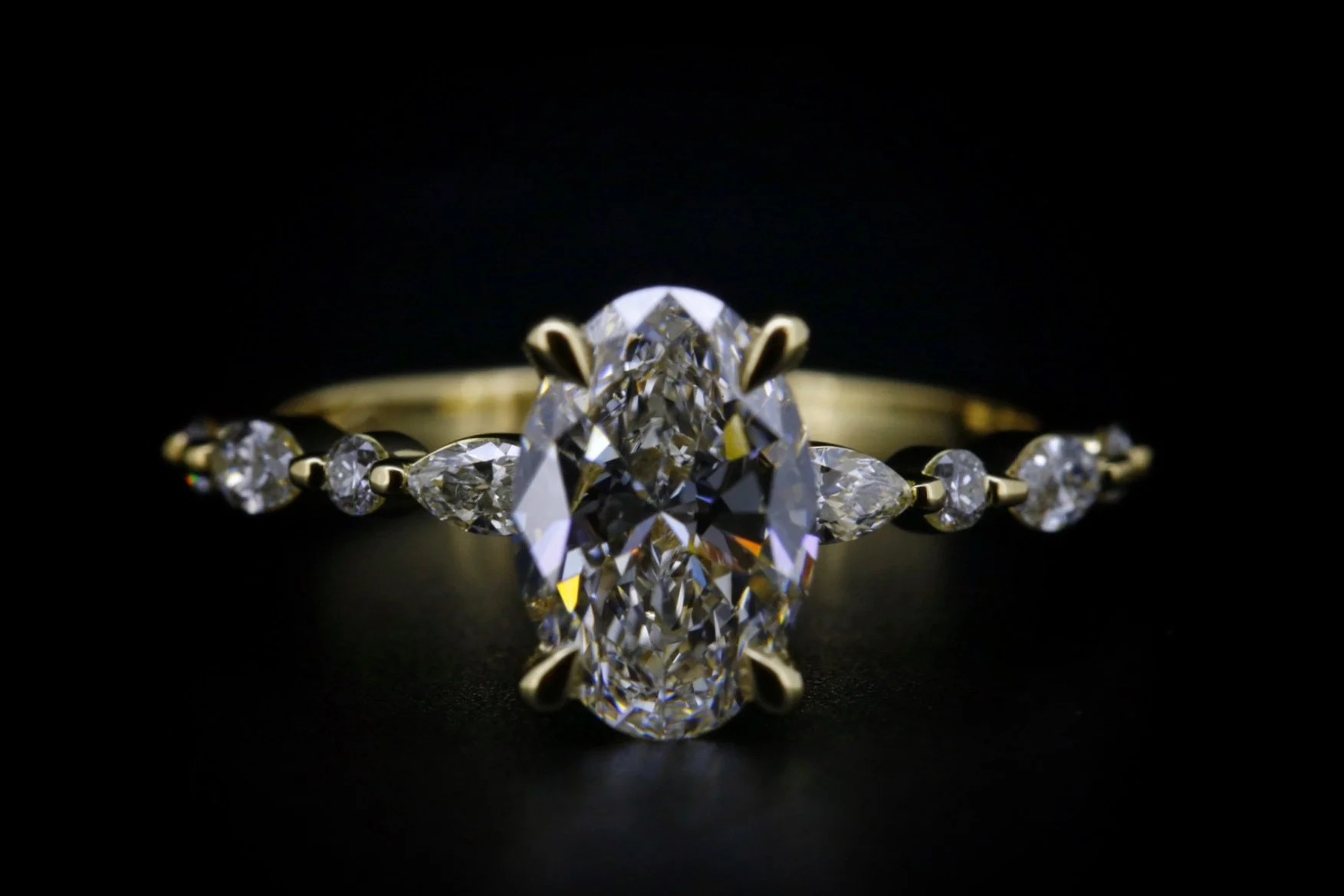 Close-up of a diamond engagement ring with a large central diamond and smaller diamonds on a gold band against a black background.