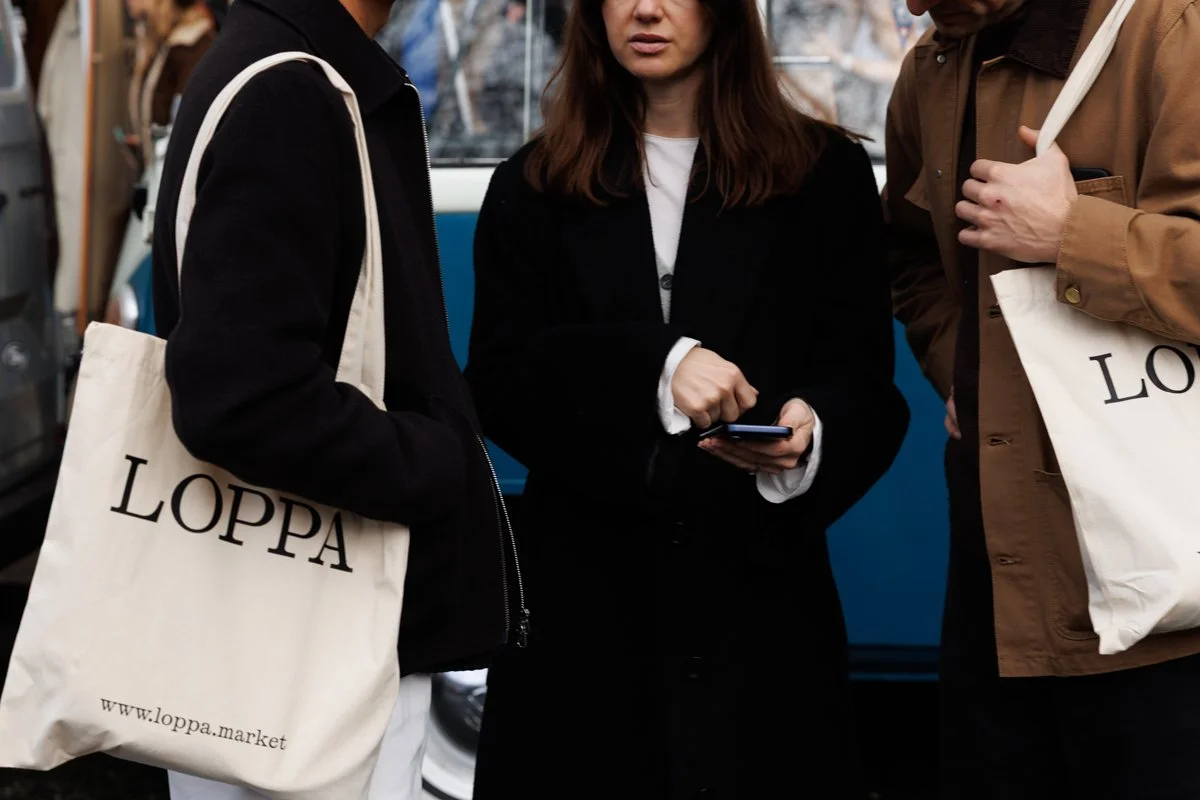 Three people standing around a phone deciding which pop up to visit next