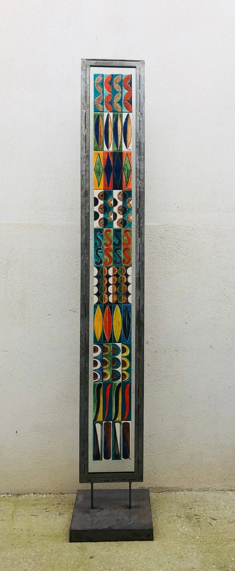 Grand totem géométrique : métal, terre cuite émaillée (azulejos) sur plexiglas -220 x 35 - réalise en 2 exemplaires.. Mentionné dans le catalogue d'exposition du Musée Magnelli Le sourire du chat - Les carreaux de Florence Patte - Auteur : Sandra B