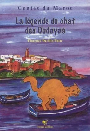 Couverture d'un livre illustré avec un chat orange sur un bateau, un village en arrière-plan, et un ciel violet.