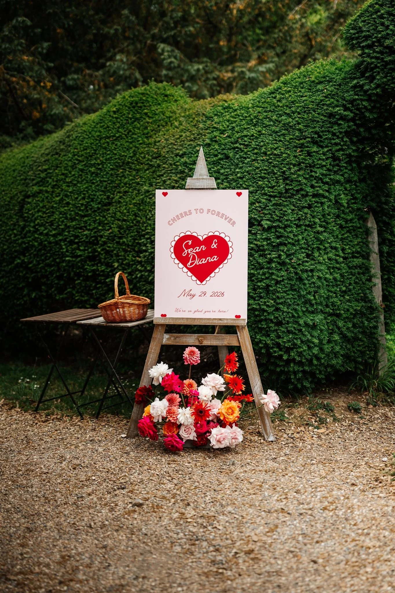 Pink and red heart wedding welcome sign with colourful flowers at Preston Court