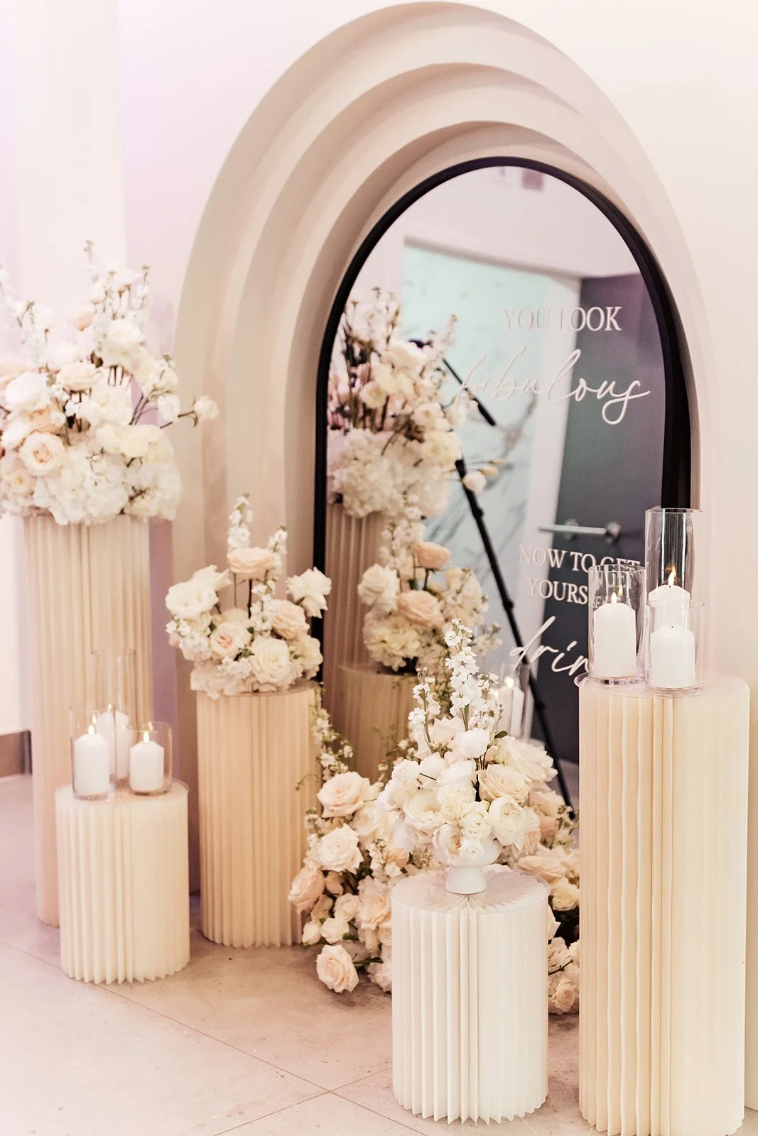 A decorated mirror with floral arrangements and candles, likely for an event or celebration.