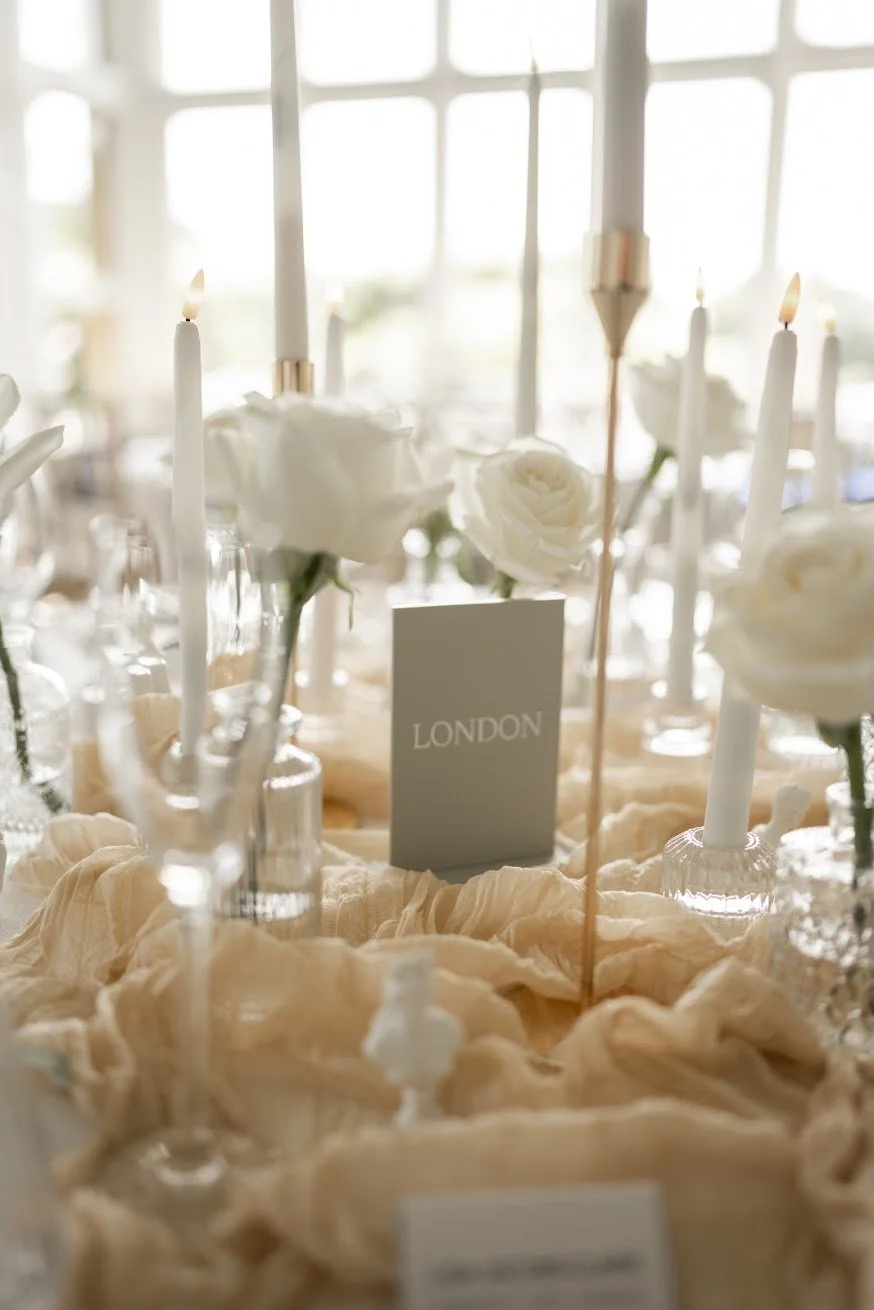 White rose bud vases and tall tapered candles on a luxury wedding tablescape