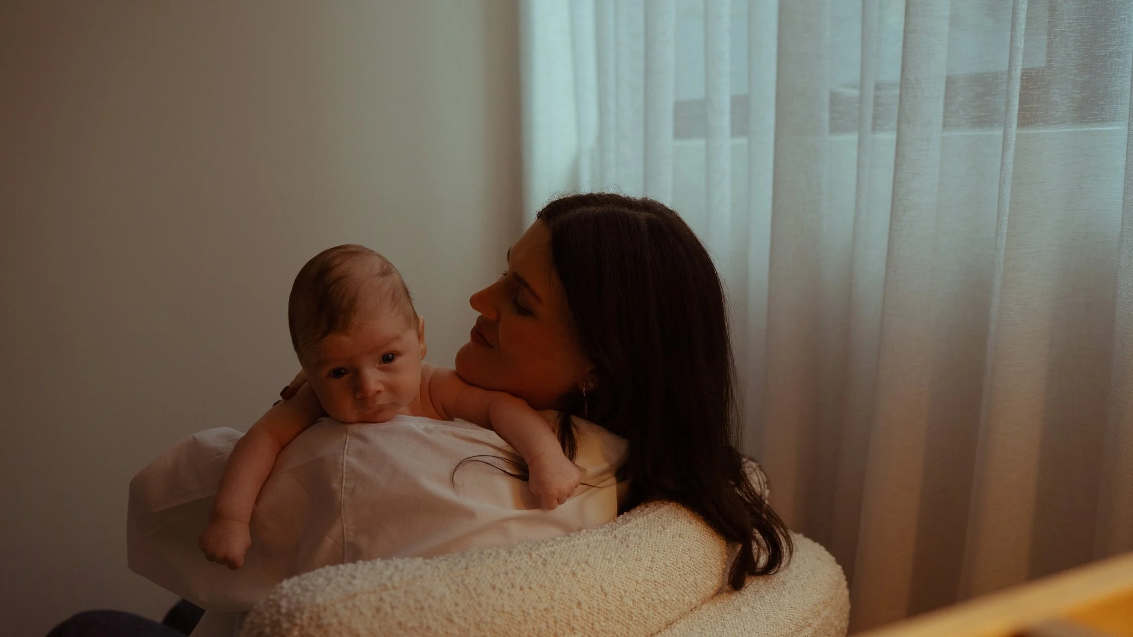 Newborn photography at home Macedon Ranges — mum resting with newborn