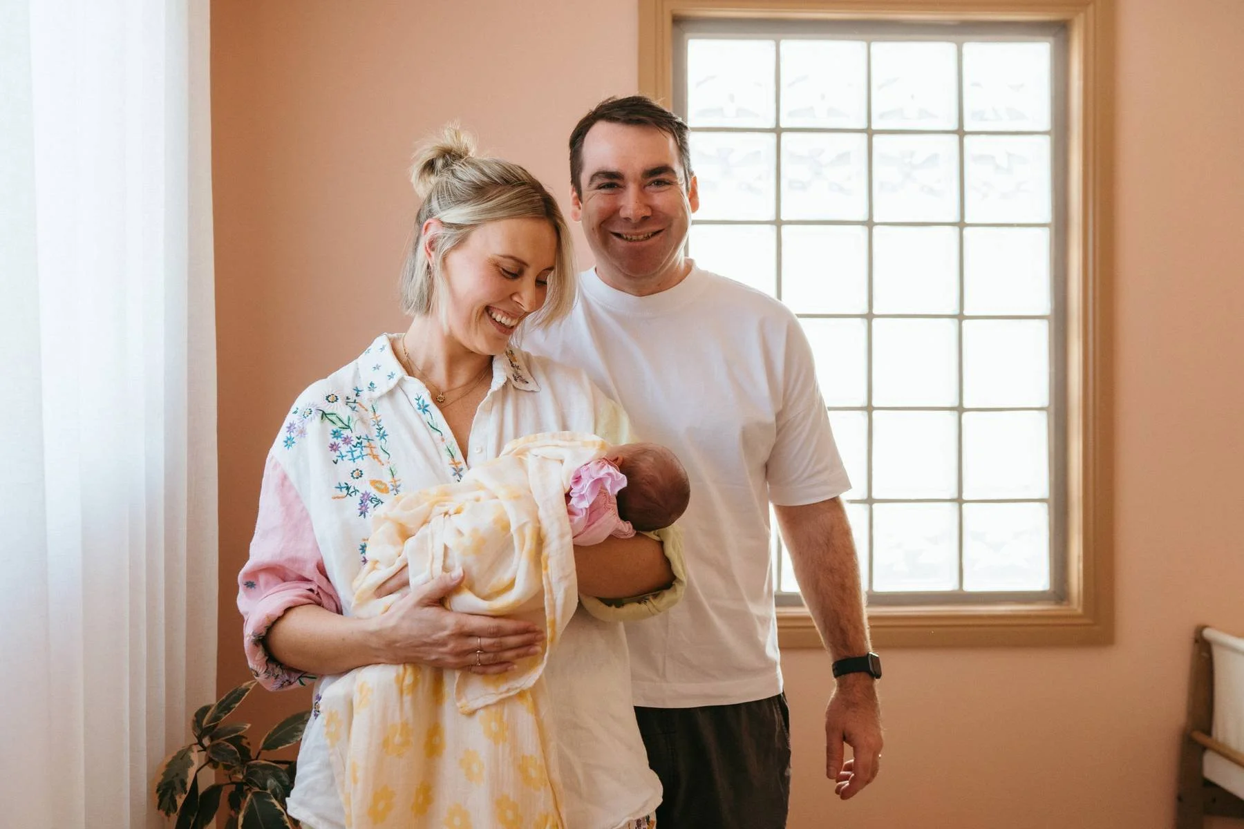 Parents cuddling their newborn during a family photography session