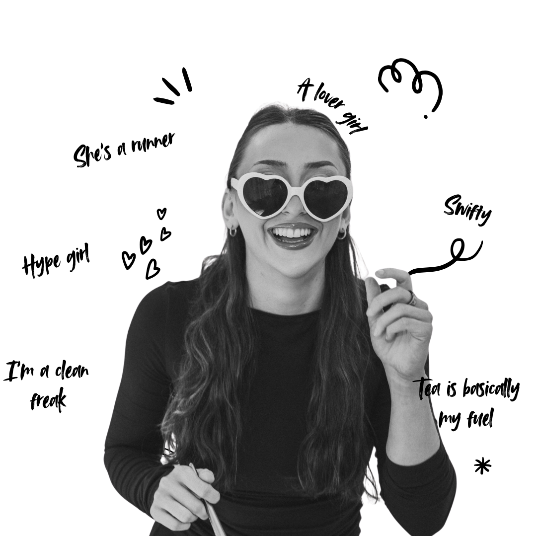 A bridal makeup artist solihull smiling into the camera with glasses on and a brush in hand. Black and white