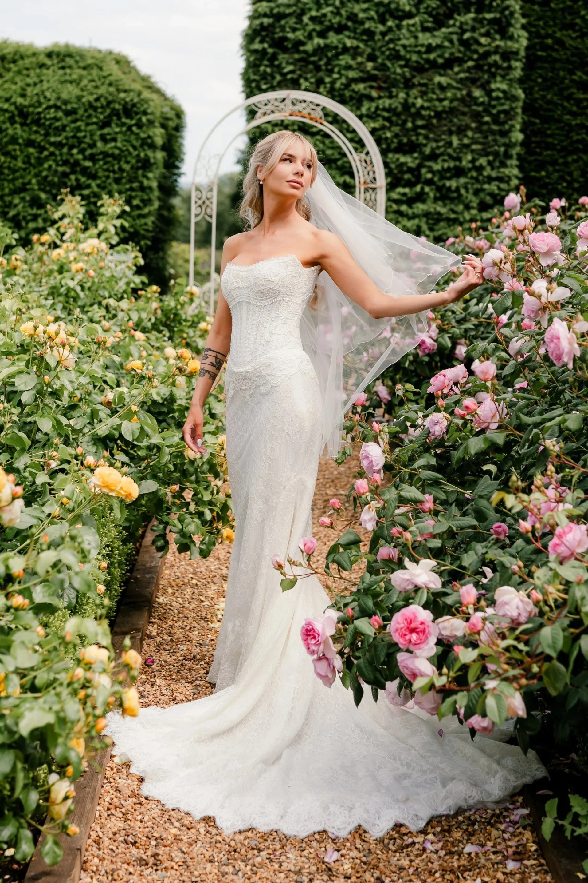 bride full length shot surrounded by pink flowers