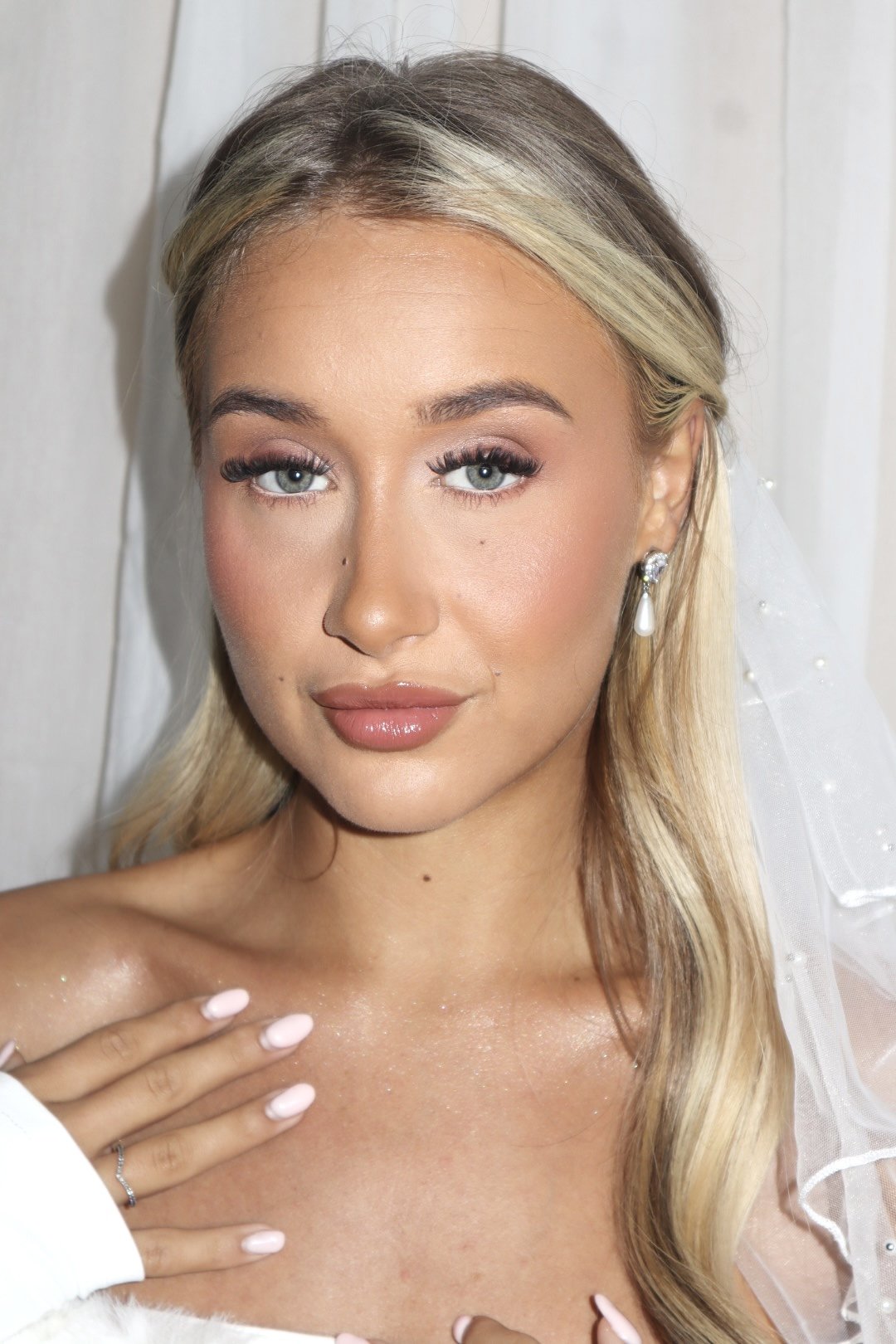 Bridal makeup on a blonde model wearing a veil and looking into the camera 